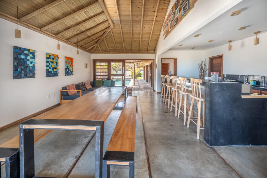 Séjour ouvert avec table en bois, bar et vue sur la piscine, La Kite Family à Pontal de Maceió