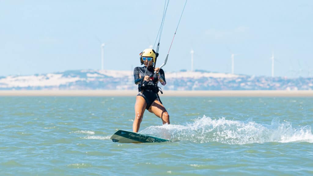 Élève en kitesurf naviguant sur une planche Eleveight avec casque et harnais, spot de Pontal de Maceió