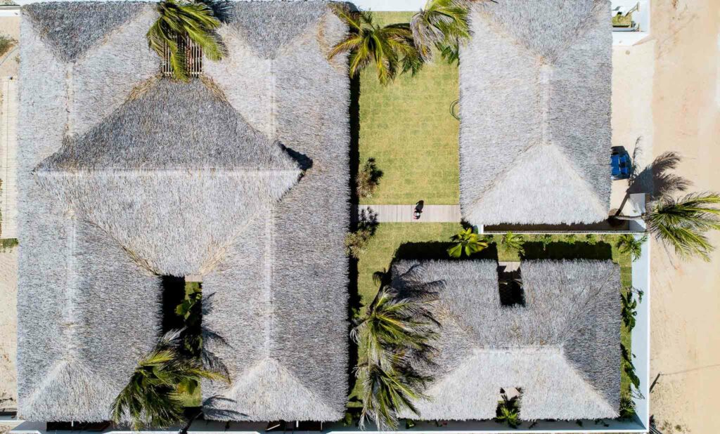 Vue drone de la pousada One Launch Kite House avec toitures en palme et pelouse tropicale à Pontal de Maceió