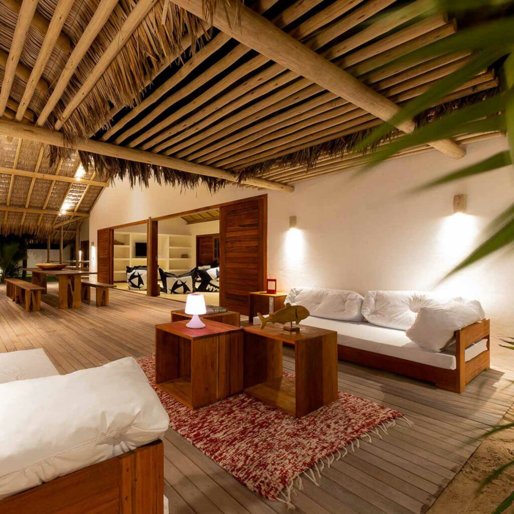 Terrasse couverte avec canapés en bois et toit en palme, ambiance de nuit à la One Launch Kite House, Fortim