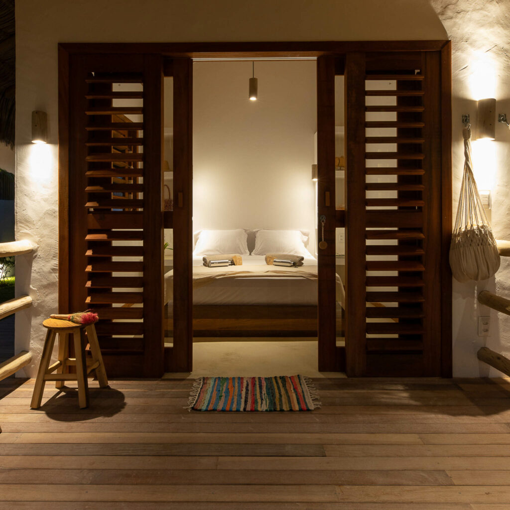 Entrée de chambre avec portes en bois ajourées et terrasse, ambiance tropicale à la One Launch Kite House