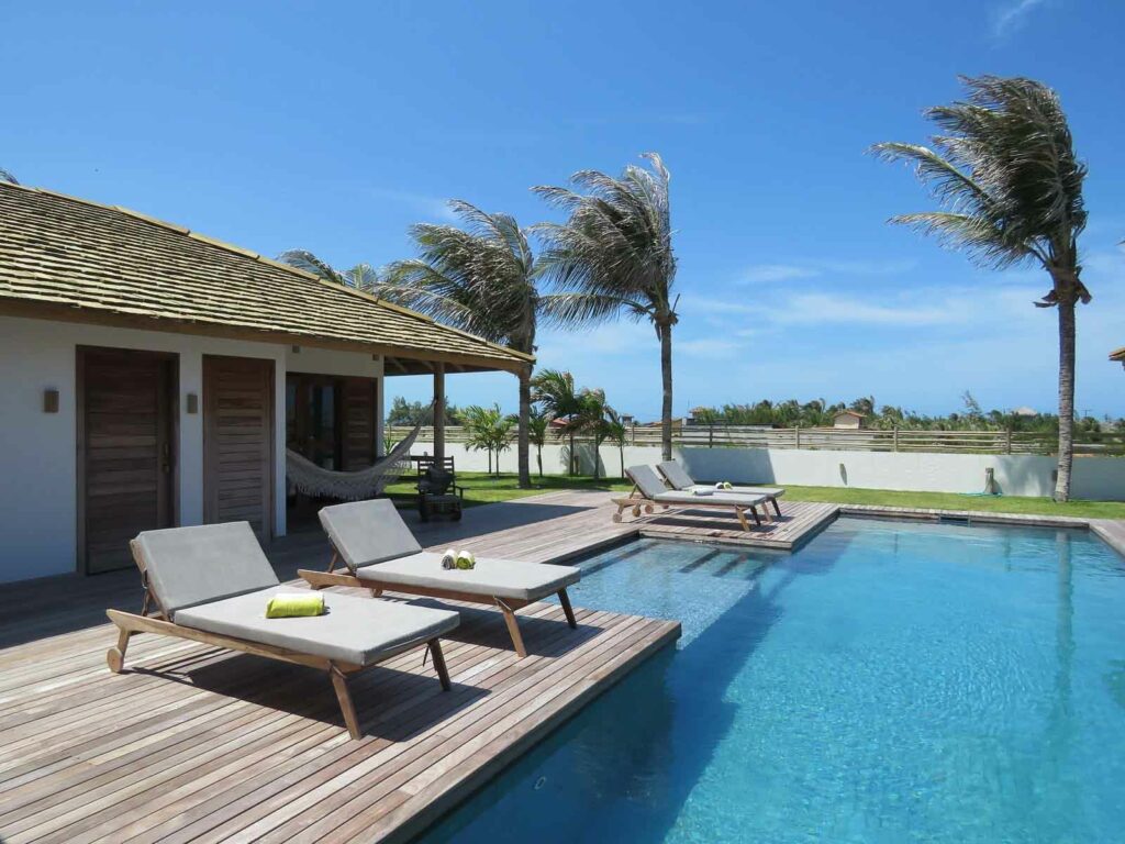 Piscine avec transats et vue mer entourée de palmiers, Kite Family+ à Pontal de Maceió, Fortim