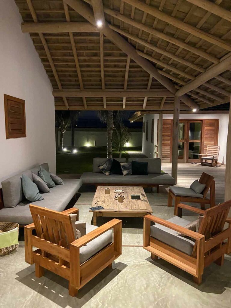 Salon extérieur couvert avec fauteuils et canapés en bois, ambiance nocturne, Kite Family+, Fortim